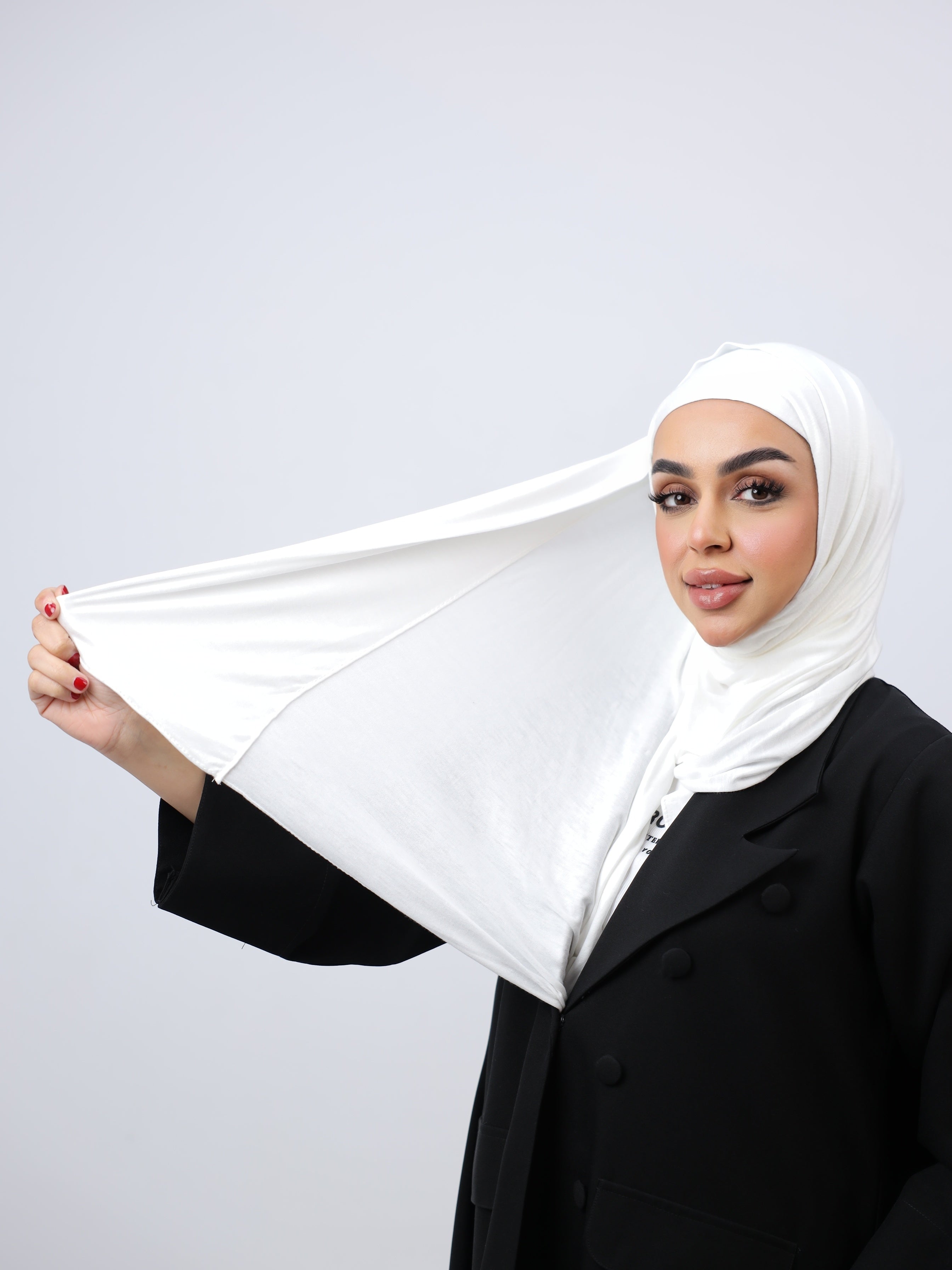 A woman wearing a white cotton double stretch hijab with a plain style.